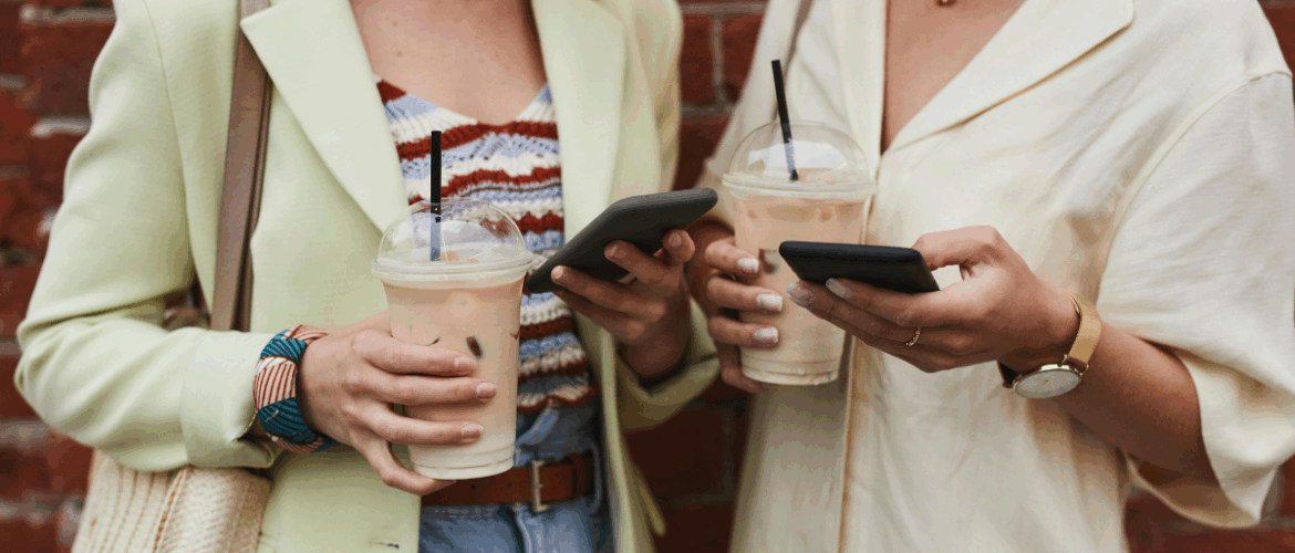 rua-almirante-barroso-pelotas-casarão-duas mulheres mexendo no celular enquanto tomam um café gelado
