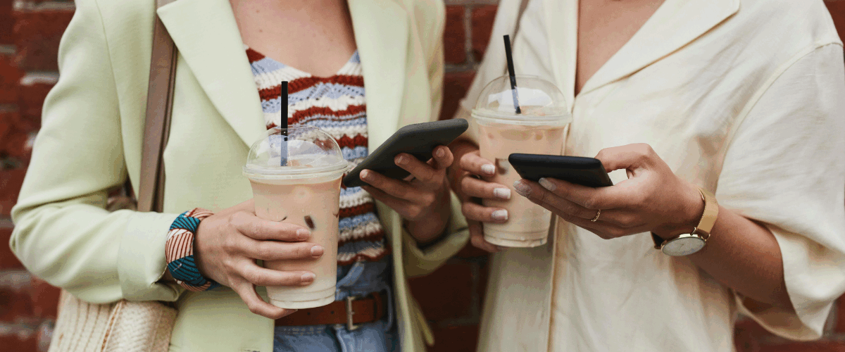 rua-almirante-barroso-pelotas-casarão-duas mulheres mexendo no celular enquanto tomam um café gelado