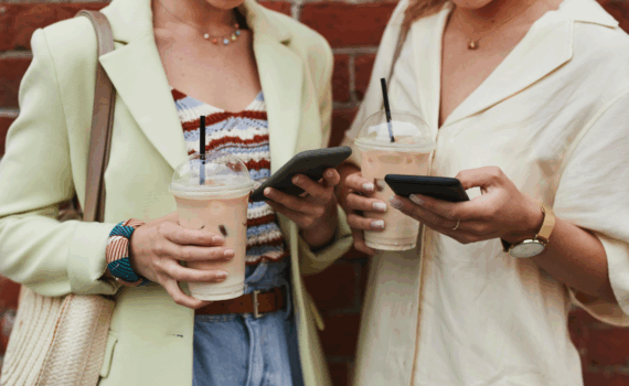 rua-almirante-barroso-pelotas-casarão-duas mulheres mexendo no celular enquanto tomam um café gelado