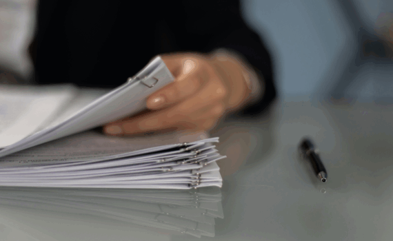 pessoas olhando uma pilha de documentos